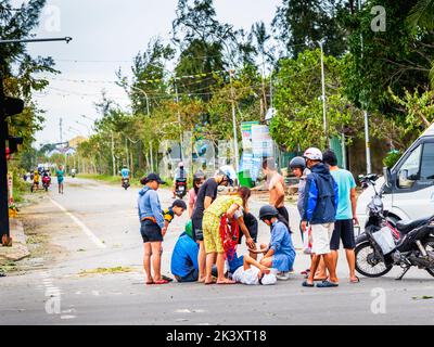 Motorradunfall mit Menschen, die an einem Mann teilnahmen, der sich am Boden an der großen Kreuzung von an Bang Beach, Vietnam, befindet. Stockfoto