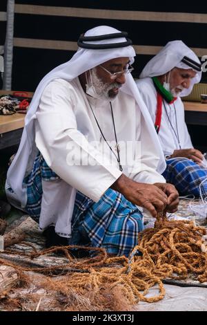 Afro-Araber aus Abu Dhabi beim Folklife Festival in dishdaha, Ghutra und Agal, das Kokosfaserseil für die Herstellung traditioneller Fischernetze herstellt. Stockfoto