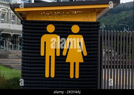 Leuchtend gelbe Symbole kennzeichnen einen öffentlichen Komfort oder eine Toilette Stockfoto