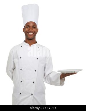 Sie entscheiden, welche Lebensmittel auf diesen Teller kommen. Ein glücklicher afrikanischer Koch bringt Ihnen Ihr Essen - Copyspace. Stockfoto