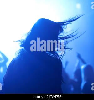 Eine Frau, die bei einem Musikkonzert tanzt. Dieses Konzert wurde für den alleinigen Zweck dieses Fotoshootings mit 300 Models und 3 Live-Bands geschaffen. Alle Stockfoto