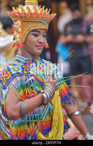 Ein junger Tänzer, der klassischen Thai-Tanz in traditioneller Thai-Tanztracht aufführt; auf dem Sunday Walking Street Market in Phuket Town, Thailand Stockfoto