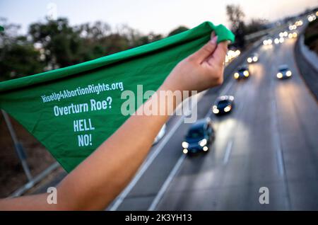 Los Angeles, Kalifornien, USA. 28. September 2022. Ein Protestler hält eine grüne Bandanna, die Abtreibungsrechte bei einem Protest mit der Gruppe Rise Up 4 Abtreibungsrechte über dem Freeway 101 in Downtown Los Angeles am ''International Safe Abort'' Tag vertritt. (Bild: © Jill Connelly/ZUMA Press Wire) Stockfoto