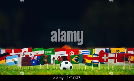 Alle 32 Flaggen und Fußball auf grünem Gras. Fußballturnier Stockfoto