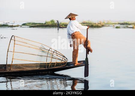 Intha Fischer Bein Rudern im traditionellen Stil auf Inle Lake, Shan Staat, Myanmar (Burma). Stockfoto