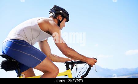 Genießen Sie die Landschaft beim Training. Beschnittene Ansicht eines Radfahrers, der entlang einer Meeresstraße radelt. Stockfoto