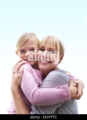 Es gibt nichts wie eine Mutterliebe. Ein glückliches junges Mädchen, das ihre Mutter draußen umarmt. Stockfoto