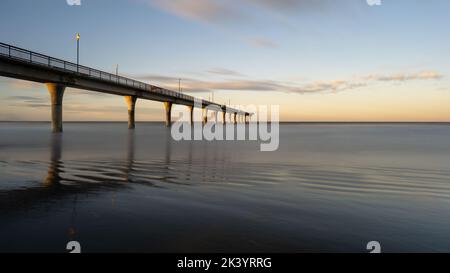 Neuer Brighton Pier bei Sonnenuntergang. Wartungsfahrzeug auf der Brücke geparkt. Christchurch, Neuseeland. Stockfoto