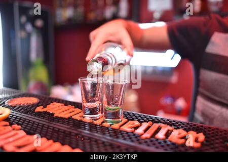 Macht Tequila-Cocktails an der Theke Stockfoto