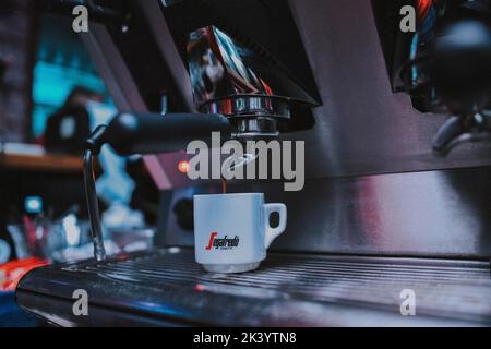Weiße Tasse unter dem Kaffeespender Stockfoto