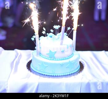 Auf dem Baby-Duschkuchen wurde ein Feuerwerk angezündet. Knabenkuchen. Stockfoto