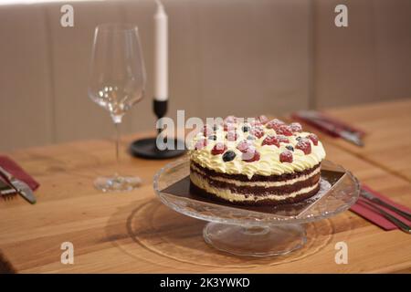 Kuchen mit Kakaoplatte, Vanillecreme und Beeren. Stockfoto