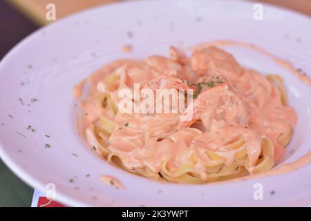 Pasta mit Garnelen und saurer Sahnesauce. Stockfoto