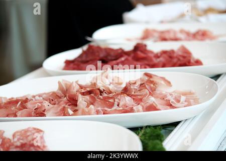 Weiße Teller mit verschiedenen Schinkenarten. Prosciutto. Stockfoto