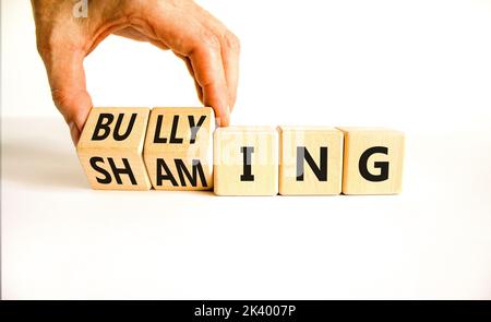 Symbol für Scham und Mobbing. Konzeptworte Shaming and Mobbing auf Holzwürfeln. Geschäftsmann Hand. Schöne weiße Tabelle weißen Hintergrund. Business-Sh Stockfoto