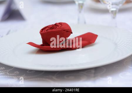 Rote Rose aus Papier auf weißem Teller Stockfoto