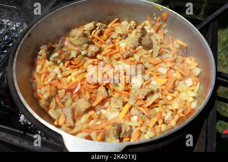 Kochen Zirvak mit Lamm und Gemüse in Kessel auf Feuer für Pilaf Stockfoto