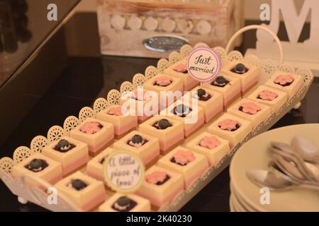 Kakao-, Vanille- und Erdbeermousse in einem weißen Tablett auf dem schwarzen Tisch Stockfoto