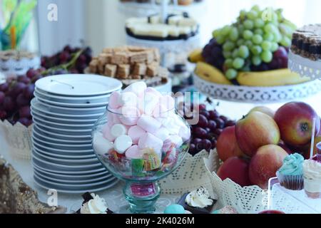 Festlicher Tisch mit Moorlachen und Gelee in einer Glasschale, und auf dem Hintergrund Früchte Stockfoto