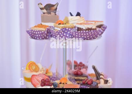 Cremeschichten Kuchen und verschiedene Früchte. Süßigkeitenbar Stockfoto