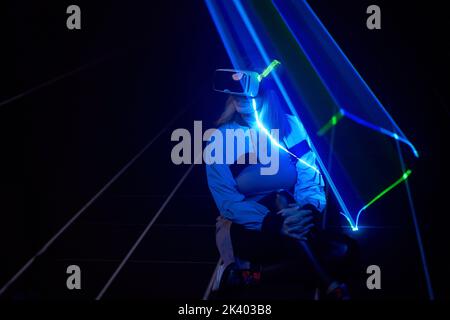 Frau nutzt Virtual-Reality-Headsets, um im Metaverse darauf zuzugreifen. Konzept der virtuellen, erweiterten und erweiterten Realität, Zukunftstechnologie, künstliches intel Stockfoto