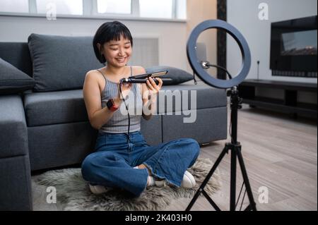 Mädchen Friseurin Aufnahme einer Frisur Tutorial-Video für ihr Publikum Stockfoto