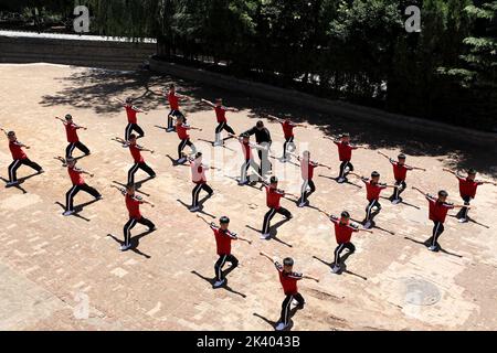 (220929) -- ZHENGZHOU, 29. September 2022 (Xinhua) -- Li Yinggang (in schwarz) unterrichtet Schüler während eines Kampfkunstunterrichts an der Shaolin Tagou Kampfkunstschule in Songshan, der zentralchinesischen Provinz Henan, 7. Juli 2022. Der 25-jährige Li Yinggang ist Coach an der Shaolin Tagou Martial Arts School in Songshan, der zentralchinesischen Provinz Henan. Im Alter von 9 Jahren begann er mit der Kampfkunst und wechselte 3 Jahre später in den freien Kampf. Seit seinem 16. Lebensjahr nimmt Li an den professionellen Freikampfwettbewerben Teil und gewann mehrmals unter anderem die Titel nationaler und internationaler Veranstaltungen Stockfoto