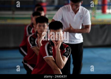 (220929) -- ZHENGZHOU, 29. September 2022 (Xinhua) -- Schüler üben während eines Kampfkunstuntergangs unter Anleitung von Trainer Li Yinggang an der Shaolin Tagou Kampfkunstschule in Songshan, Provinz Henan, 6. Juli 2022. Der 25-jährige Li Yinggang ist Coach an der Shaolin Tagou Martial Arts School in Songshan, der zentralchinesischen Provinz Henan. Im Alter von 9 Jahren begann er mit der Kampfkunst und wechselte 3 Jahre später in den freien Kampf. Seit seinem 16. Lebensjahr nimmt Li an den professionellen Freikampfwettbewerben Teil und gewinnt sogar die Titel nationaler und internationaler Kampfspiele Stockfoto