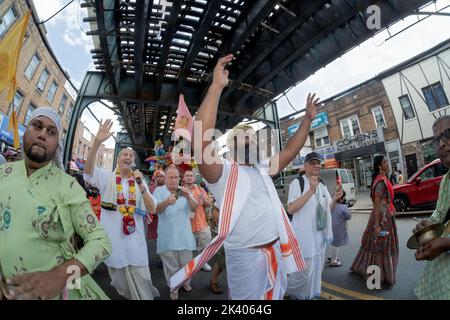 Ekstatische Hare Krishna Hindus tanzen und spielen Musik unter der erhöhten U-Bahn bei der jährlichen Ratha Yatra Parade in Richmond Hill, Queens, New York. Stockfoto
