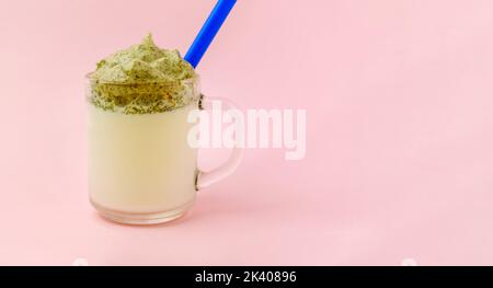 Dalgona Matcha Latte, rosa Hintergrund. Matcha grüner Tee. Trendiges Getränk. Superfoods. Milchgetränk. Koreanischer Drink Stockfoto