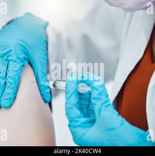 Medizin, Gesundheitswesen und Arzt, der während einer Pandemie einen kovidierten Impfstoff gegen einen Patienten im Krankenhaus verabreicht. Nahaufnahme der Hände eines Arztes mit Handschuhen Stockfoto
