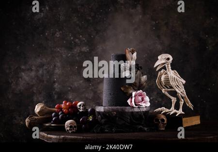 Halloween Stillleben mit Totenkopf, Knochen und Kuchen Stockfoto
