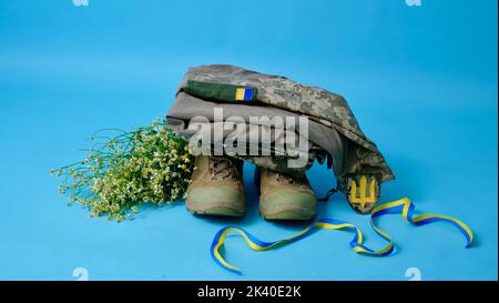 Militäruniform eines ukrainischen Soldaten der Streitkräfte der Ukraine 2022 auf einem isolierten blauen Hintergrund in einem Nahaufnahme-Studio im Krieg mit Russland. Kleidung eines wahren Helden Stockfoto