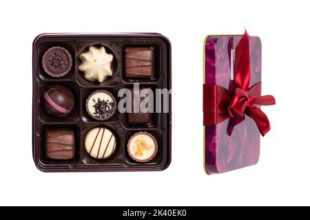 Nahaufnahme einer Schachtel mit feinen Schokoladen-Bonbons in einer schönen Plastikbox, isoliert auf weißem Hintergrund. Überraschungsgeschenk zum Valentinstag oder anderen festlichen Tagen Stockfoto