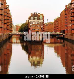 Burg im Lagerhausviertel von Hamburg am frühen Morgen, UNESCO-Weltkulturerbe, von der Poggenmuehlen-Brücke aus gesehen, Stockfoto