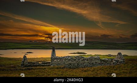 Sonnenuntergang über einer alten Croft auf den Shetland Inseln Stockfoto