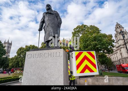 London, Großbritannien. 29 September 2022 . Ein Arbeiter auf einem Kirschenpflücker von historischen Denkmälern Restaurierung bürstet die Statue des ehemaligen Kriegsführers und Premierministers Sir Winston Churchill auf dem Parliament Square mit einem Mantel aus Wachs. Kredit: amer ghazzal/Alamy Live Nachrichten. Stockfoto