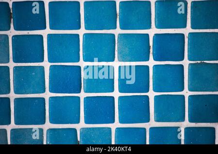 Hintergrund von kleinen blauen Fliesen, die ein typisches Gitter eines Schwimmbads oder Badezimmers bilden Stockfoto