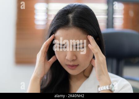 Porträt einer gestressten asiatischen Geschäftsfrau im Büro. Burnout-Syndrom oder Terminprojektkonzept Stockfoto