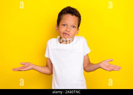 Foto von niedlichen stilvollen Jungen Arm Schulter heben nicht wissen Frage oops sorry suchen leeren Raum auf gelbem Hintergrund isoliert Stockfoto