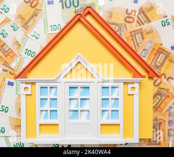 Hausmodell auf dem Hintergrund der Banknoten. Stockfoto