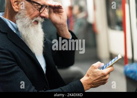 Hipster Senior man Mobiltelefon, während er auf den U-Bahn-Zug wartet - Weiche Fokussierung auf die rechte Hand Stockfoto