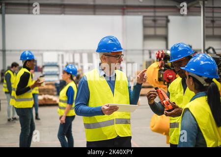 Multirassische Ingenieure, die in einer Roboterfabrik arbeiten - Weiche Konzentration auf das linke Gesicht des Mannes Stockfoto