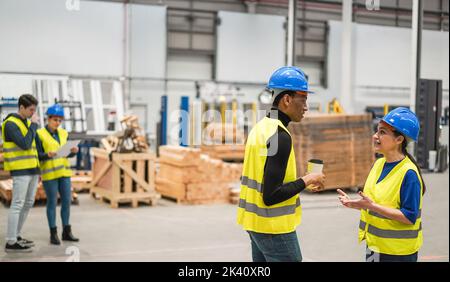 Multirassische Ingenieure, die in einer Roboterfabrik arbeiten – Fokus auf die richtigen Gesichter Stockfoto