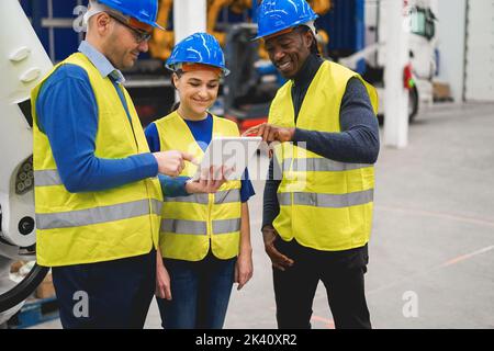 Multirassische Ingenieure, die innerhalb der Roboterfabrik arbeiten - Industrie- und Technologiekonzept Stockfoto