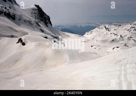 Chamonix, Frankreich - 27. März 2022: Alleinerziehender männlicher Offpiste-Skifahrer auf schneebedecktem Bergrücken nach dem Sandstaubsturm der Sahara mit Blick auf den Winter vista Stockfoto