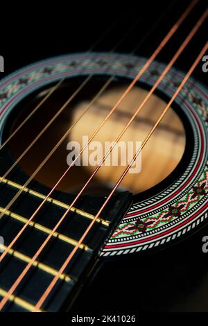 Die Saiten einer klassischen schwarzen Gitarre Stockfoto