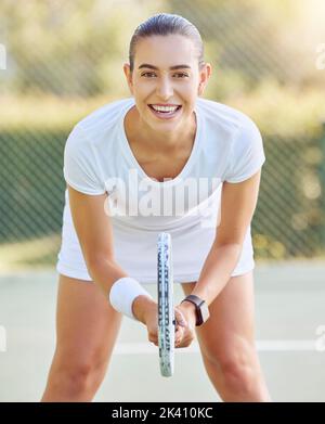 Porträt einer Tennisfrau mit einem Schläger auf dem Tennisplatz, die sich auf ein Spiel vorbereitet. Junger, konkurrenzfähiger Tennisspieler mit einem Tennisschläger Stockfoto