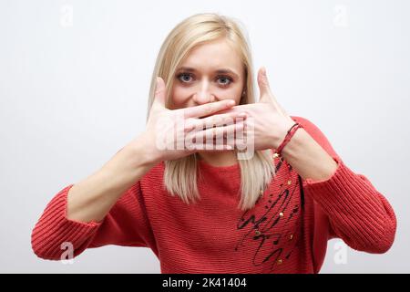 Frau macht eine leisende Geste, indem sie ihren Finger auf ihre Lippen hebt, während sie um Schweigen bittet oder um deine Hilfe bei der Aufbewahrung eines geheimen Stockfotos Stockfoto