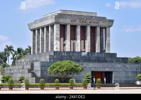 Das stattliche Ho Chi Minh Mausoleum wurde an einem sonnigen Tag von drei Wachen in weißer Uniform beobachtet. Stockfoto